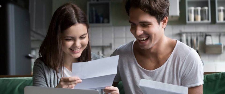 couple happy looking at bills