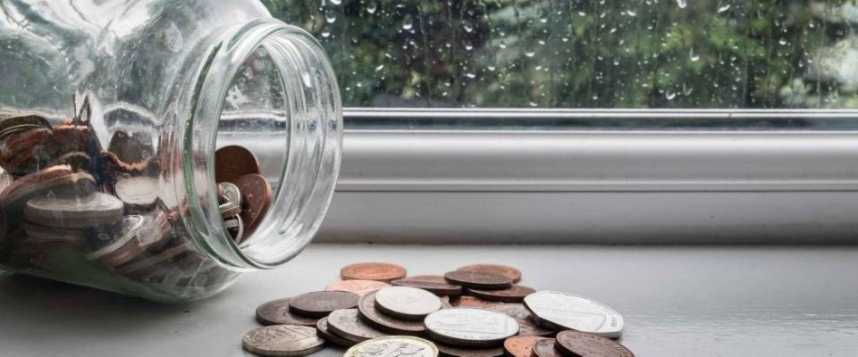 Jar of english money with rainy day background