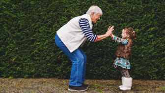 A grandma high-fives her little granddaughter