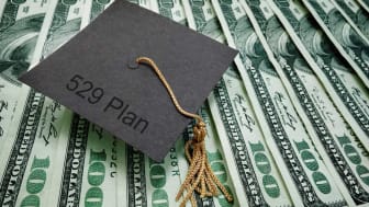 picture of graduation cap sitting on money