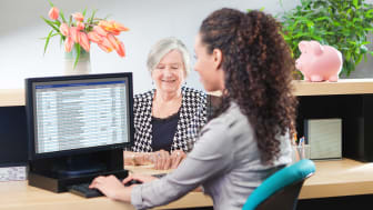 Senior woman working with a teller in a bank