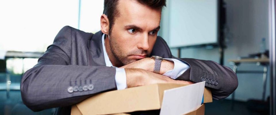Businessman fired from work sitting sad at office