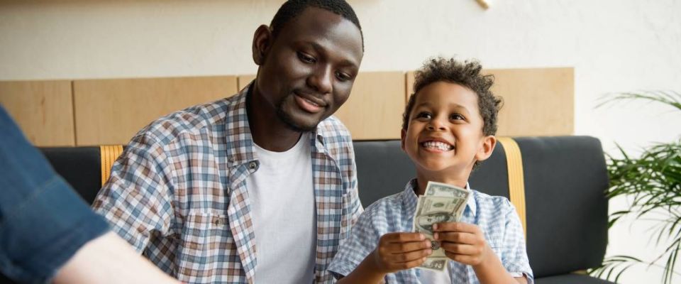 Father and son sitting together son hold american bills currency