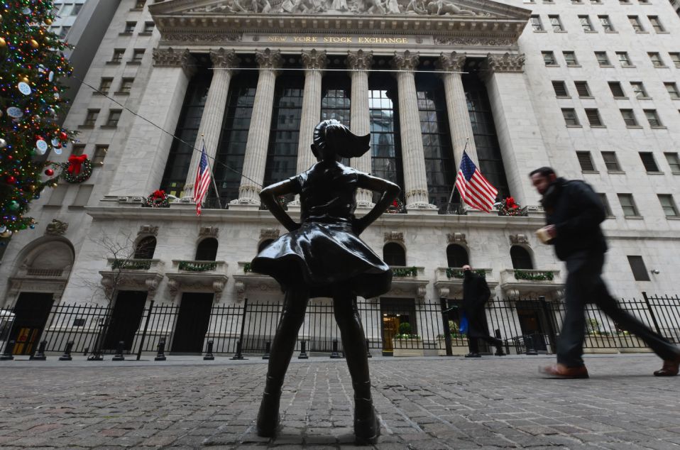People walk past the New York Stock Exchange (NYSE) and 'Fearless Girl' statue at Wall Street on December 9, 2020 in New York City. (Photo by Angela Weiss / AFP) (Photo by ANGELA WEISS/AFP via Getty Images)