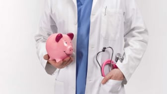 picture of a doctor holding a piggy bank