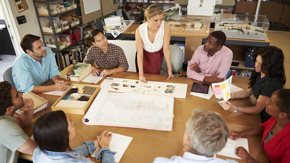Female Boss Leading Meeting Of Architects Sitting At Table - Image.