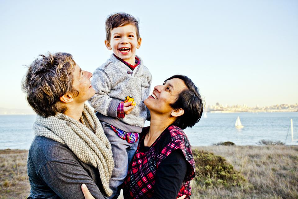 Portrait of lesbian family with toddler son (2-3) smiling outdoors, San Francisco, California, USA