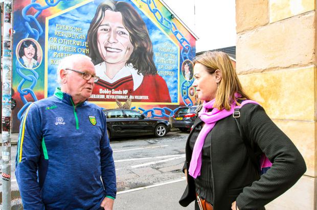 Nicola Tallant and Jake Mac Siacais at the Bobby Sands mural on the Falls Road in Belfas