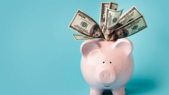 A piggy bank is overflowing with cash.