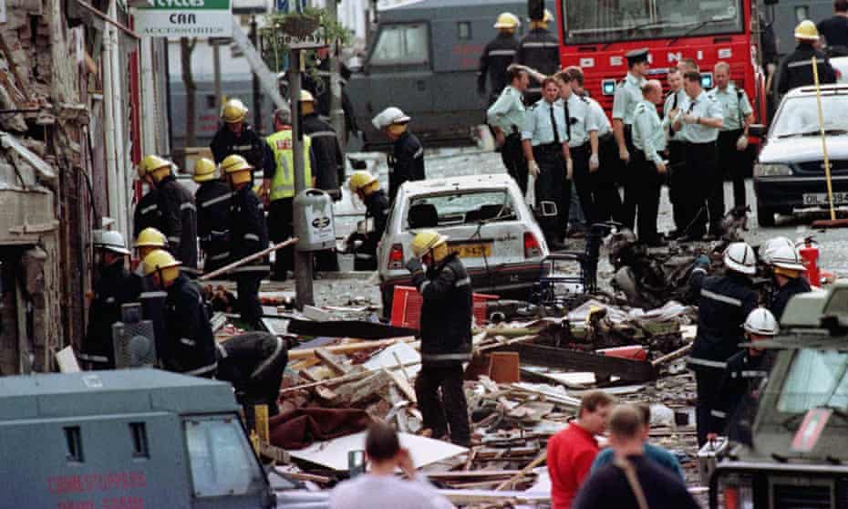 Police and firefighters inspect the damage caused by the explosion in Market Street, Omagh