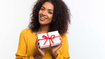 A woman holds a wrapped gift.