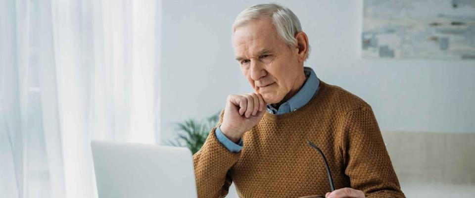 Senior confident man working on laptop