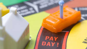 A board game with a toy car reaching the &quot;Pay Day&quot; spot.